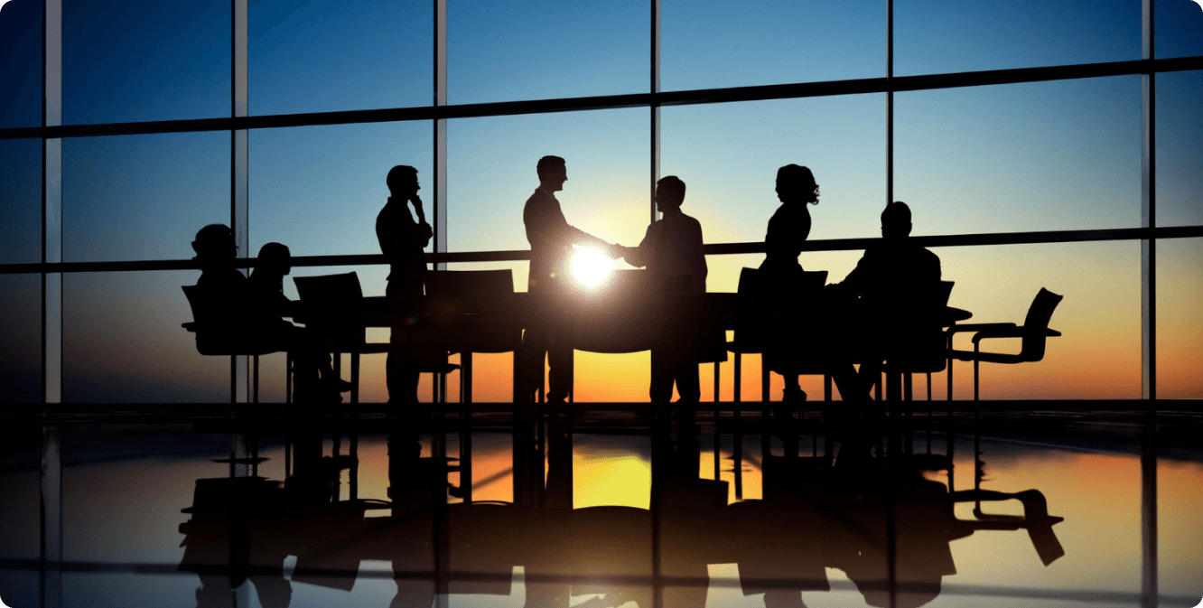 Team meeting silhouette against sunset